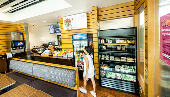 The interior of Ullman To Go with refrigerators for premade snacks, salads and drinks next to a counter for ordering