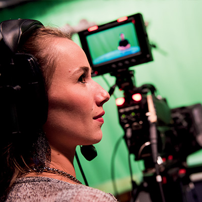 student operating camera in studio
